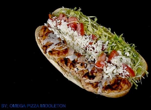 Grilled chicken sub with shredded lettuce, diced tomatoes, white sauce, and crumbled feta cheese.