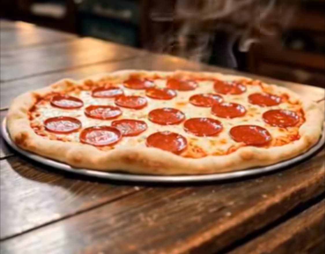 Steaming pepperoni pizza with melted cheese on a metal tray and a rustic wooden table.